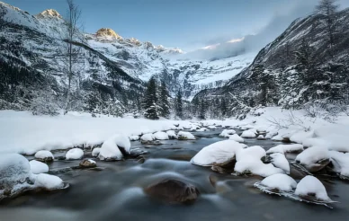 Hiver au Cirque de Gavarnie. Paysage enneigé et rivière gelée du Cirque de Gavarnie en hiver.