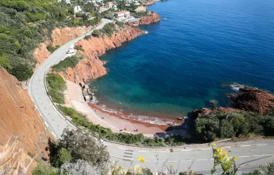 Anse turquoise et falaises rouges sur la Corniche d’Or, Massif de l’Esterel. Vue de la Corniche d’Or et des roches rouges au bord de l’eau, Massif de l’Esterel.