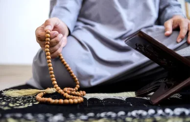 كيفية ختم دعاء ناد علي لقضاء الحوائج شخص مسلم يمسك بمسبحة أثناء جلوسه لختم دعاء ناد علي لقضاء الحوائج وتفريج الهموم.