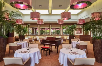 Salle de restaurant chic du Casino Barrière Ribeauvillé avec piano et décoration élégante.
