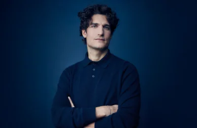 Louis Garrel posant en studio dans une atmosphère élégante et épurée.