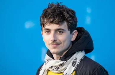 Timothée Chalamet style décontracté portrait. Timothée Chalamet portrait fond bleu.