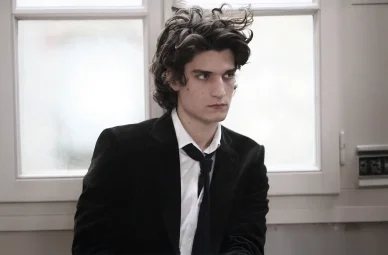 Louis Garrel dans une scène intérieure au style dramatique et épuré.
