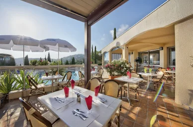 Pause gourmande en terrasse avec vue, aux portes du Massif de l’Esterel. Terrasse ensoleillée avec tables dressées et piscine, séjour près du Massif de l’Esterel.