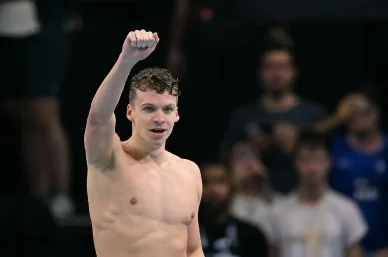 Victoire en finale : Léon Marchand lève le poing.