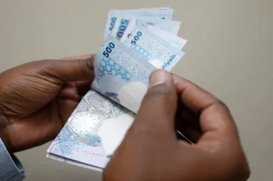 عد الأوراق النقدية من فئة 500 ريال قطري يدان تقومان بعد مجموعة من الأوراق النقدية للريال القطري من فئة 500 ريال.