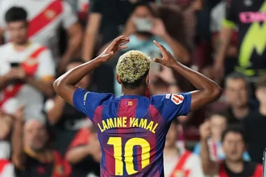 لاعب فريق برشلونة لامين يامال من الخلف يضع يديه على رأسه، مرتدياً القميص رقم 10 أمام الجماهير في المدرجات.