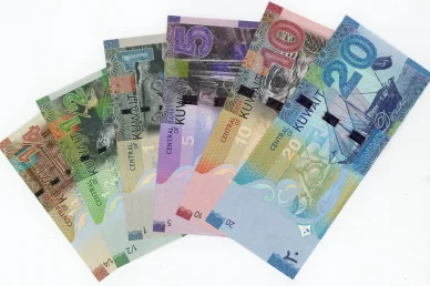 تشكيلة كاملة من فئات الدينار الكويتي الورقية مرتبة على شكل مروحة على خلفية بيضاء.