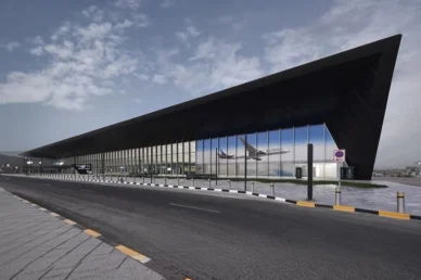 مبنى مطار حديث بواجهة زجاجية تعرض طائرة للخطوط الجوية الكويتية، يمثل البنية التحتية للسفر.