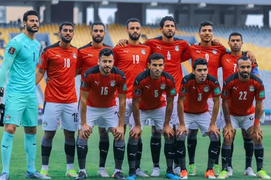 التشكيلة الأساسية لمنتخب مصر لكرة القدم تصطف لالتقاط صورة جماعية قبل بداية المباراة على أرض الملعب.