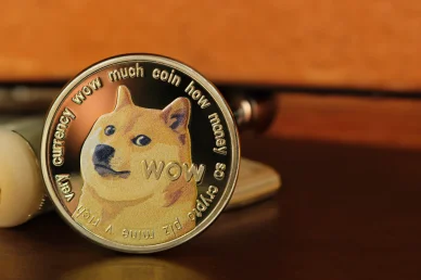 Représentation dorée d’une pièce Dogecoin. Pièce Dogecoin posée sur une table.