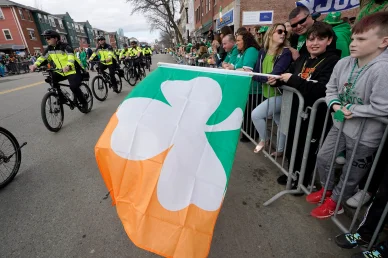 St. Patrick's Day parade with Irish flag and shamrock.