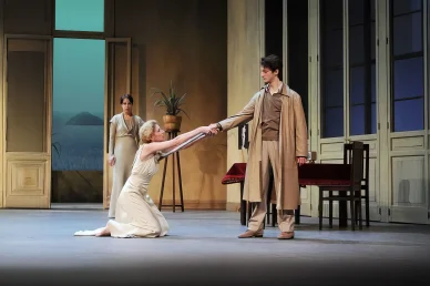 Le comédien Pierre Niney sur scène dans une pièce de théâtre, une actrice à genoux lui tenant la main.