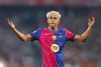 لاعب فريق برشلونة لامين يامال يرفع يديه بتعبير متسائل أثناء مباراة على أرض الملعب.