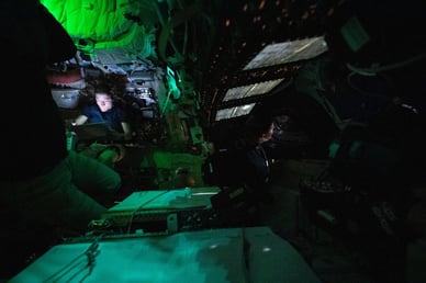NASA astronaut Christina Koch is illuminated by a screen inside the darkened Orion spacecraft on the third day of the agency's Artemis II mission.