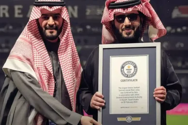 إنجاز عالمي: شهادة غينيس لأكبر ملعب داخلي في الرياض رجلان يرتديان الزي السعودي التقليدي يحملان بفخر شهادة موسوعة غينيس للأرقام القياسية لأكبر ملعب كرة قدم داخلي