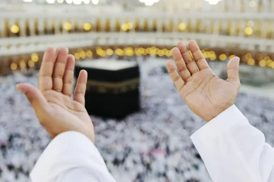 لقطة قريبة ليدي حاج مرفوعتين بالدعاء أمام الكعبة المشرفة في الحرم المكي الشريف.