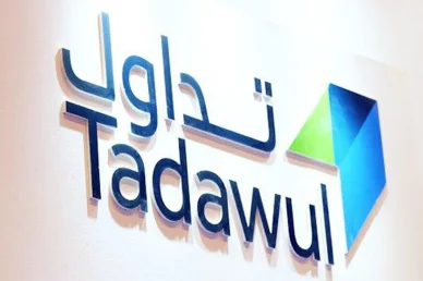 شعار مجموعة تداول السعودية: السوق المالية الرائدة في المنطقة شعار تداول ثلاثي الأبعاد باللغتين العربية والإنجليزية مثبت على حائط أبيض