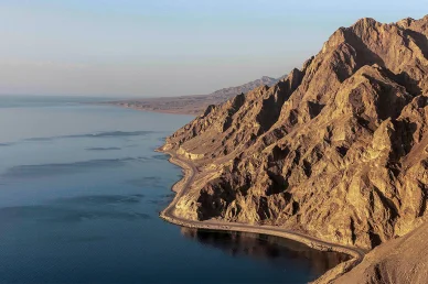 طبيعة نيوم الساحرة: الطريق الساحلي بين الجبال والبحر طريق ساحلي يمتد بين جبال صخرية شاهقة ومياه البحر الأزرق الهادئة