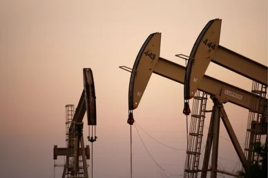 مضخات الطاقة وتأثير الإنتاج على الاقتصاد العالمي مضخات النفط (Oil Pumpjacks): مضخات استخراج النفط تعمل في حقل نفطي تحت سماء الغروب الدافئة.