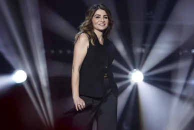 Julie Zenatti sur scène avec un micro pendant un concert.