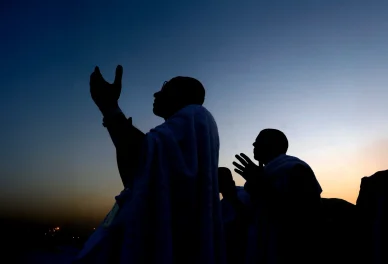 حجاج بملابس الإحرام يرفعون أيديهم بالدعاء والتضرع وقت الغسق.