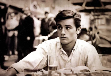 Alain Delon jeune en noir et blanc à une terrasse de café.