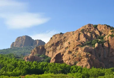 Paysage minéral et forêt méditerranéenne, Massif de l’Esterel. Grandes parois rocheuses ocre et pinèdes en premier plan, Massif de l’Esterel.