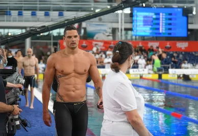 Florent Manaudou se prépare avant une nouvelle épreuve de natation. Florent Manaudou marche au bord du bassin après une compétition.