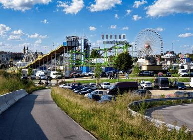 Blick auf die Kisselswiese am Rheinufer mit Riesenrad, Achterbahn und Fahrgeschäften beim Wormser Backfischfest