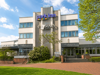 Außenansicht des Casino Lübeck im Park Inn by Radisson mit Haupteingang und Begrünung
