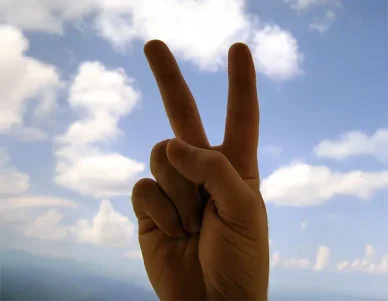 Image symbolique de paix utilisée pour illustrer Vidéo en Poche. Main formant un signe de paix dans le cadre d’une illustration associée à Vidéo en Poche.