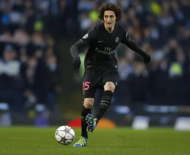 Adrien Rabiot jouant un match de Ligue des champions avec le PSG. Adrien Rabiot en plein contrôle du ballon avec le PSG.