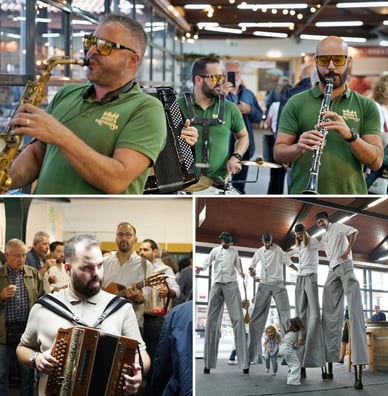 O grupo Ruído à Portuguesa com saxofone, acordeão e clarinete, um acordeonista no meio do público e artistas em andas vestidos de cozinheiros com crianças