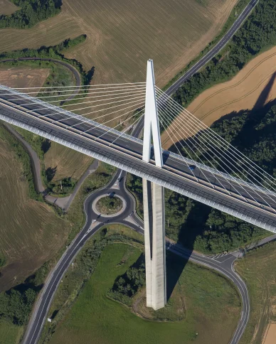 Vue aérienne d’un pylône du Viaduc de Millau et des routes environnantes.