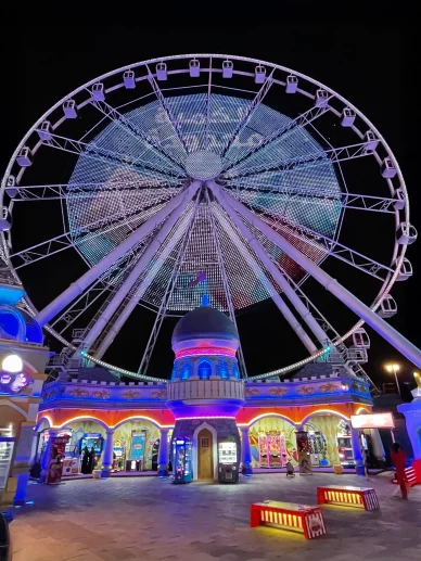 عجلة فيريس في مدينة الملاهي بالقرية العالمية